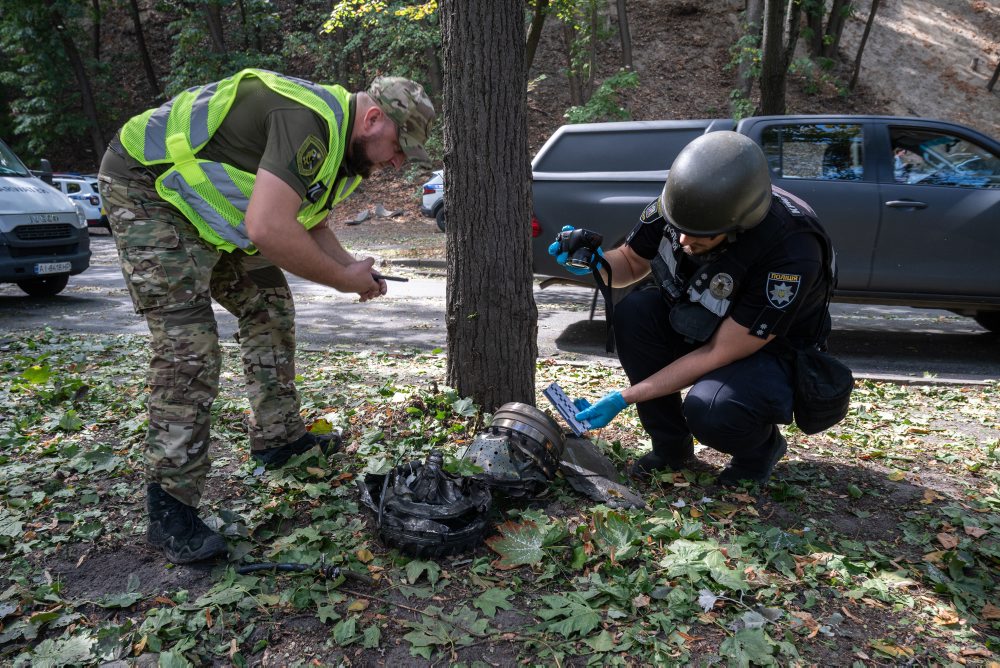 Policajti si prezerajú úlomky dronu v Kyjeve 